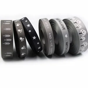 Rotoli di nastro grosgrain grigio decorativo con motivi e testo per regali e imballaggi.