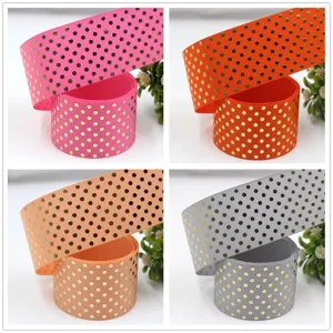 Detailed close-up of 38mm metallic gold polka dot grosgrain ribbon for crafts and gift wrapping.