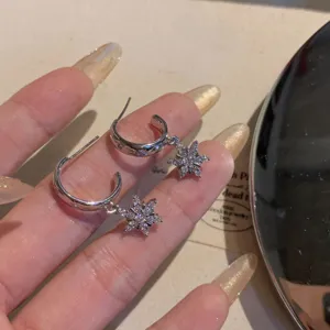 Silver star snowflake cubic zirconia hoop earrings, sparkling daily commute jewelry detail.