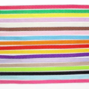 Dettaglio nastro grosgrain colorato con bordo impunturato bianco, perfetto per il fai da te e regali.