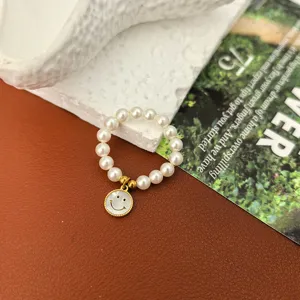 Nahaufnahme eines stilvollen Perlenrings mit süßem Smiley-Anhänger für Damen Modeschmuck.
