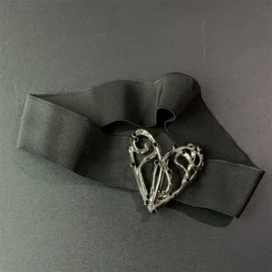 Primer plano detallado de la elegante hebilla de corazón metálica plateada en el cinturón.