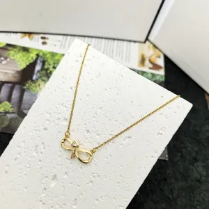 Gold titanium steel infinity loop zircon necklace detail, elegant 8-shape clavicle chain jewelry.