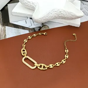 Gold stainless steel anchor chain bracelet with cubic zirconia paved links, minimalist chic.