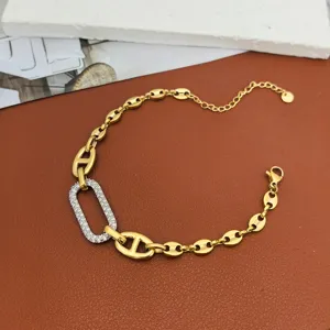 Gold stainless steel link bracelet featuring a sparkling zircon oval pendant design.