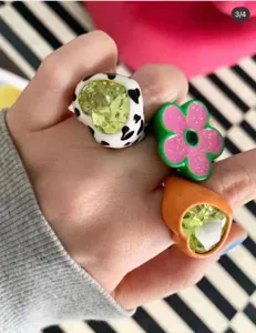 Close-up detail shot of French vintage style resin colorful chunky rings with flower and heart shapes.