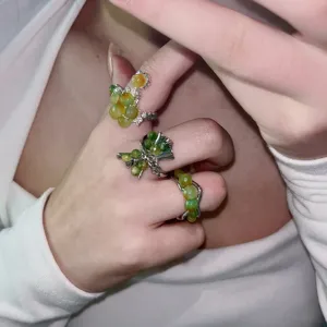 Close-up detail of unique green beaded rings, handmade lava style open ring, elegant accessory.