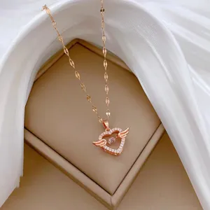 Delicate rose gold heart necklace detail, featuring sparkling wing pendant and dynamic center stone.