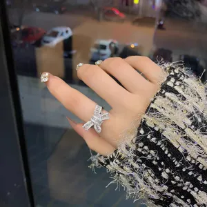 Sparkling crystal bow ring detail close-up, elegant cubic zirconia finger jewelry aesthetic.