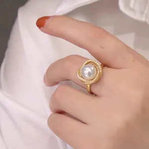 Close-up detail of luxury pearl ring with sparkling cubic zirconia crystals on gold band.