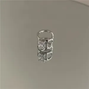 Minimalist silver C-shaped ear cuff with sparkling geometric cubic zirconia stone detail.