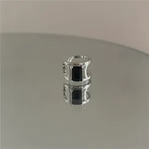 Minimalist C-shaped metal ear cuff with a dark rectangular zircon for women, chic style.