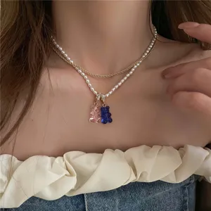 Primer plano detallado de collar doble de perlas con bonitos colgantes de osito de goma.