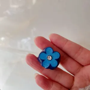 Blue five-petal flower ring detail, resin glitter finger jewelry with shiny rhinestone center.