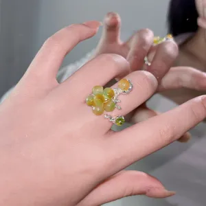 Close-up of handmade lava open ring with natural green and yellow gemstone beads for women.