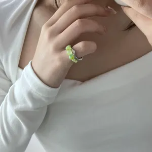 Handmade green bead ring with irregular silver lava band, unique niche design detail.