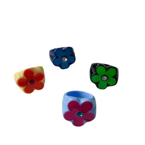 Chunky colorful resin five-petal flower rings with sparkling rhinestone center design.