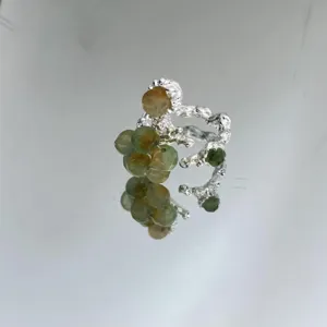 Handmade silver lava ring with green raw stone beads, detailed close-up shot showing unique texture.