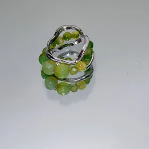 Close-up detail shot of the handmade green beaded ring with unique metal lava open design.