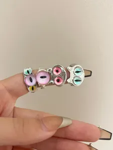 Close-up detail of stackable cat eye monster open rings, unique cool style jewelry.