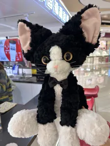 Cute black and white Devon Rex cat plush toy with curly fur and bow tie detail for gift.