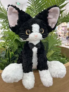 Detail view of the cute black and white Devon Rex plush cat toy with soft curly fur bow tie.