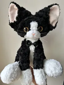 Cute black and white Devon Rex cat plush toy, curly fur stuffed kitty doll with bow tie.