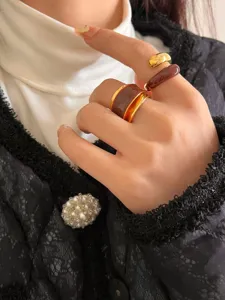 Detailed close-up of liquid enamel double-layer open ring in chic chocolate gold style.