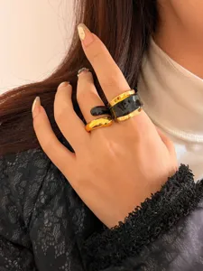 Close-up of trendy liquid enamel double-layer gold and black open ring worn on hand.