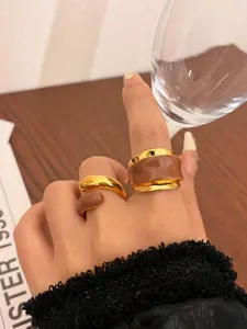 Close-up detail of liquid enamel double-layer open ring in chic brown and gold color.
