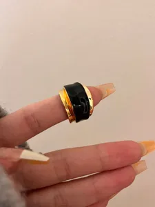Close-up detail of the black enamel double-layer open ring, showcasing the unique fluid design.