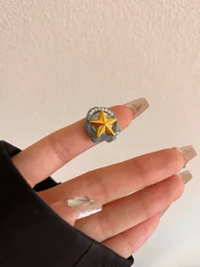 Detail van brede metalen open ring met handgemaakte oliedruppel ster en mooie parels.