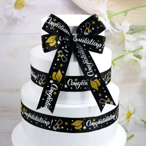 Black and white graduation ribbon 3.8cm wide with gold stamped congratulation and cap patterns.