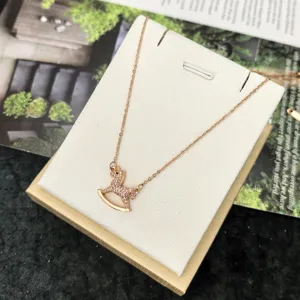 Rose gold rocking horse pendant necklace with sparkling cubic zirconia crystals for women.