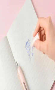 Primo piano dettagliato di una penna stilografica cancellabile rosa su taccuino a righe.
