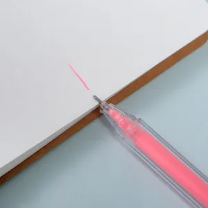 Primo piano dettagliato di un evidenziatore rosa pastello che scrive pulito sul taccuino.