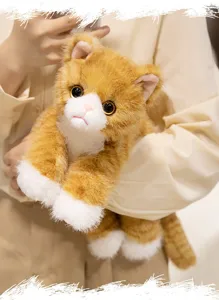 Close-up detail of a cute orange and white kitten plush toy held in hands, soft toy.