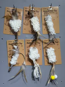 Natural wool cat teaser toy with feathers and wooden handle hanging on backing card display details.