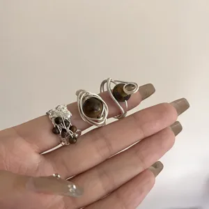 Gros plan de bagues en oeil de tigre en fil de fer fait main, presentation de bijoux empilables.