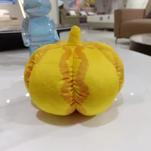 Gros plan d'une peluche citrouille jaune montrant un tissu doux et des détails.