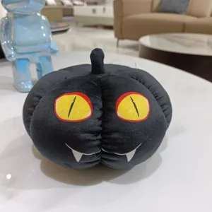 Adorable peluche citrouille noire d'Halloween avec des yeux de chat jaunes et poupée.