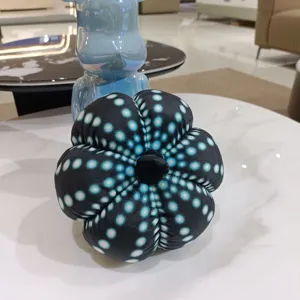 Gros plan détaillé d'une peluche citrouille à pois noirs et bleus, texture douce.