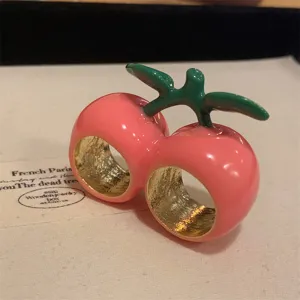 Detailopname van een dubbele kersenring met roze emaille en groen stengelontwerp.