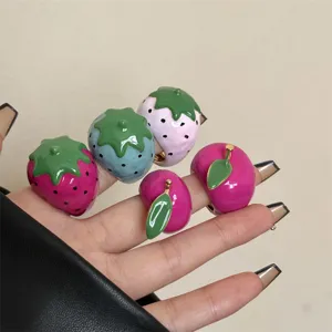 Close-up van kleurrijke geëmailleerde aardbeienringen stapelbare macaron fruitringen.