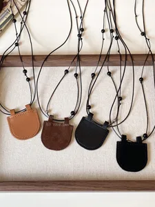 Detailed view of leather sunglasses holder necklace, portable magnetic glasses lanyard storage accessory.