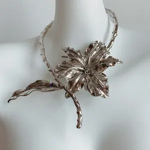 Gros plan d'un collier choker en métal argenté avec fleur, bijoux style punk audacieux.