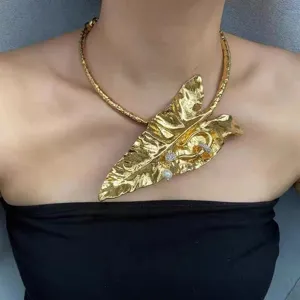 Collier choker exagéré en métal doré feuille de bananier avec perles et détails cristaux.