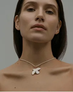 White ceramic peace dove pendant necklace with braided cord, elegant fashion jewelry accessory.