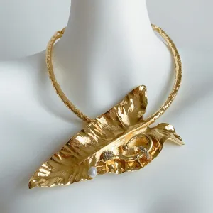 Gros plan détaillé du collier ras de cou chunky feuille de bananier dorée avec perle strass.