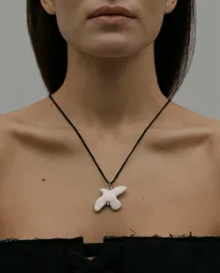 White ceramic dove pendant necklace with black cord. Elegant fashion sweater chain accessory.